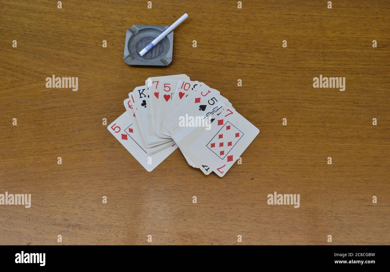 Kartenspiel, bekannt als Spielkarten, Aschenbecher und Zigaretten, auf einem alten Bretttisch, Brasilien, Südamerika Stockfoto