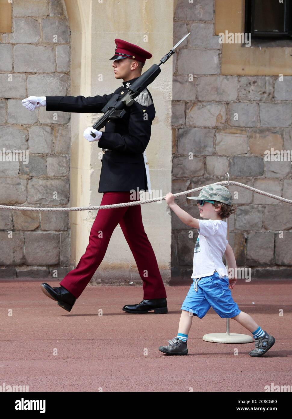 BILDUNTERSCHRIFT KORREKTUR: Ändert den Namen des Regiments und entfernt die Beschreibung von ihnen als Wachmänner. Ein junger Besucher imitiert den marsch eines Soldaten aus den königlichen Hussaren des Königs im Schloss Windsor, der nach Aufhebung weiterer Beschränkungen durch die Sperrung des Coronavirus in England wieder für die Öffentlichkeit zugänglich gemacht wurde. Stockfoto