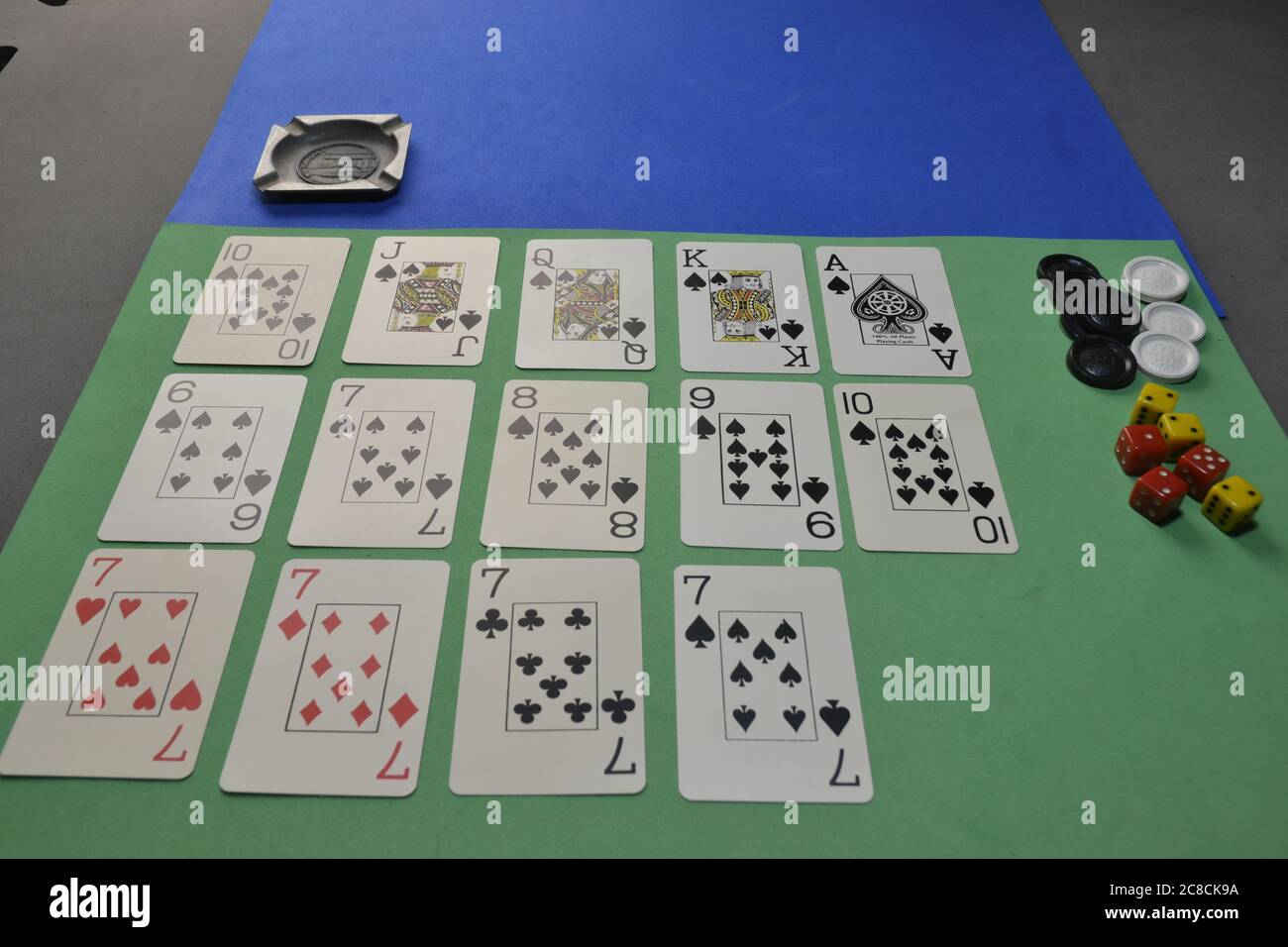 Poker-Spiel auf einem grünen und blauen Tisch, mit Chips und Würfel in einem Foto mit selektivem Fokus, Panoramablick Stockfoto