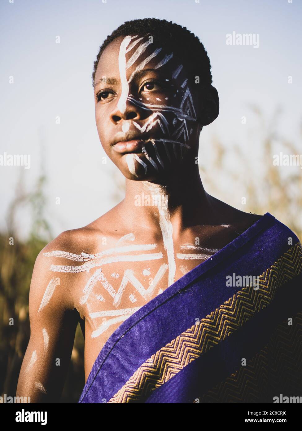 Porträt eines afrikanischen Jungen mit ethnischer Gesichtsfarbe und Dressing im Busch Stockfoto