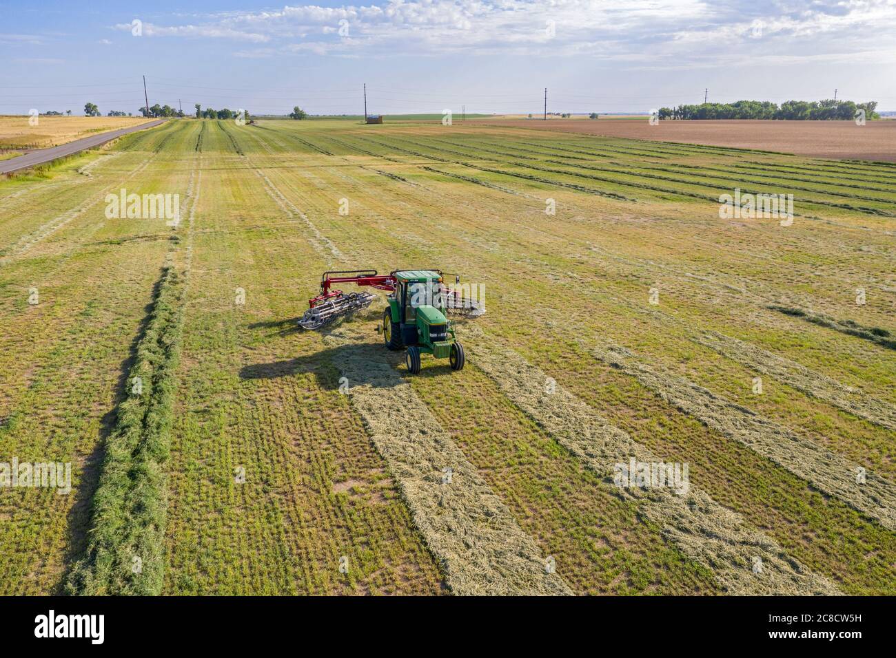Hudson, Colorado - EIN Bauer zieht einen Tinstar G3 Heuharke durch ein Feld im Osten Colorados. Stockfoto