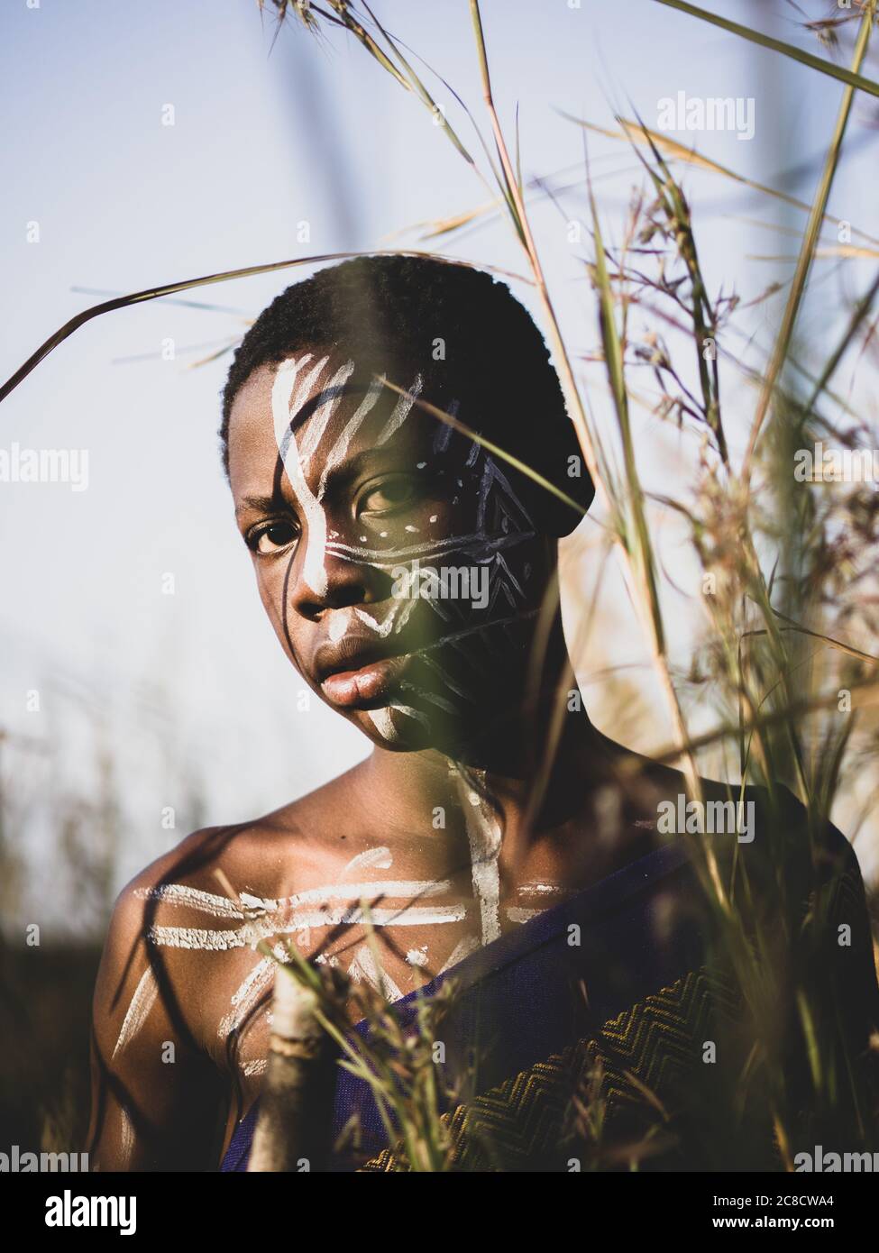 Porträt eines afrikanischen Jungen mit ethnischer Gesichtsfarbe und Dressing im Busch Stockfoto