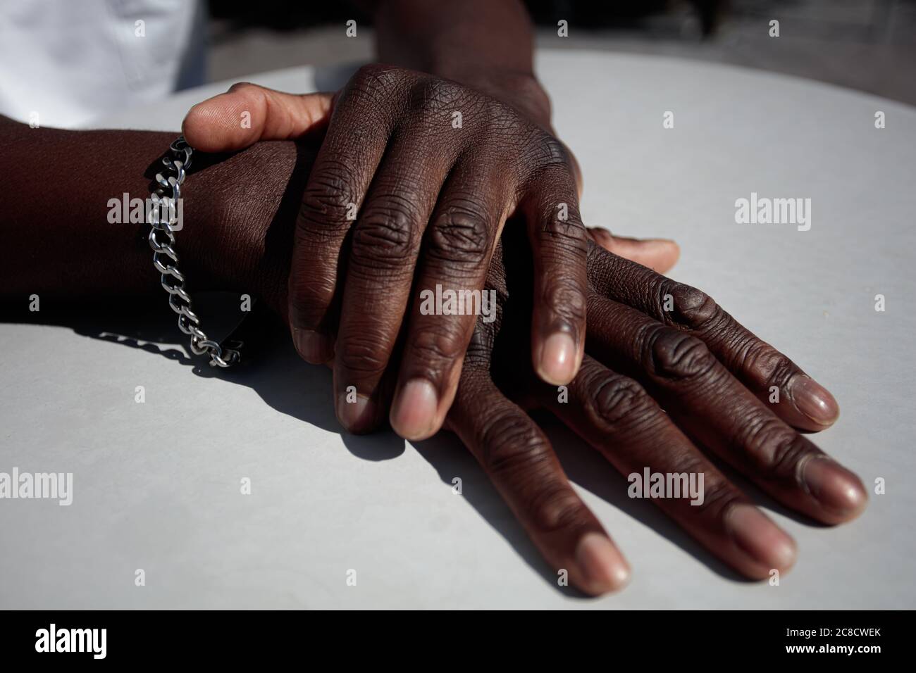 Nahaufnahme, Hände auf dem Tisch, der Mann ist Afrikaner. Schwarze Haut. Hochwertige Fotos Stockfoto