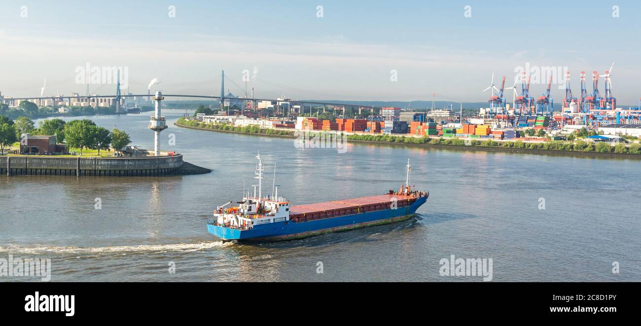 Panoramaaufnahme eines Containerschiffes, das in Richtung Hafen und Containerterminal an der Elbe in Hamburg steuert Stockfoto