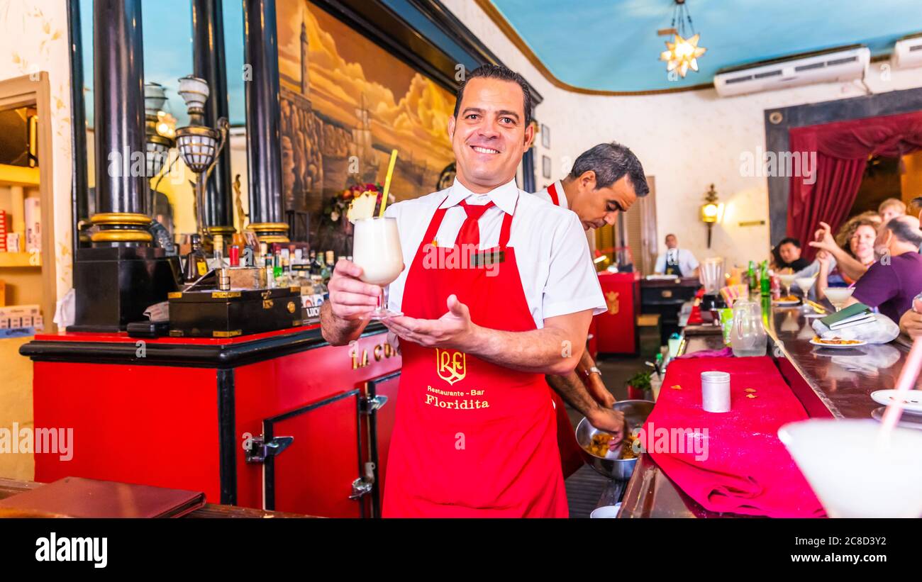 Havanna / Kuba - 04.15.2015: Barkeeper, der in der berühmten kubanischen Bar Floridita einen Pina Colada Cocktail serviert, mit einem Lächeln auf dem Gesicht, Havanna, Kuba Stockfoto