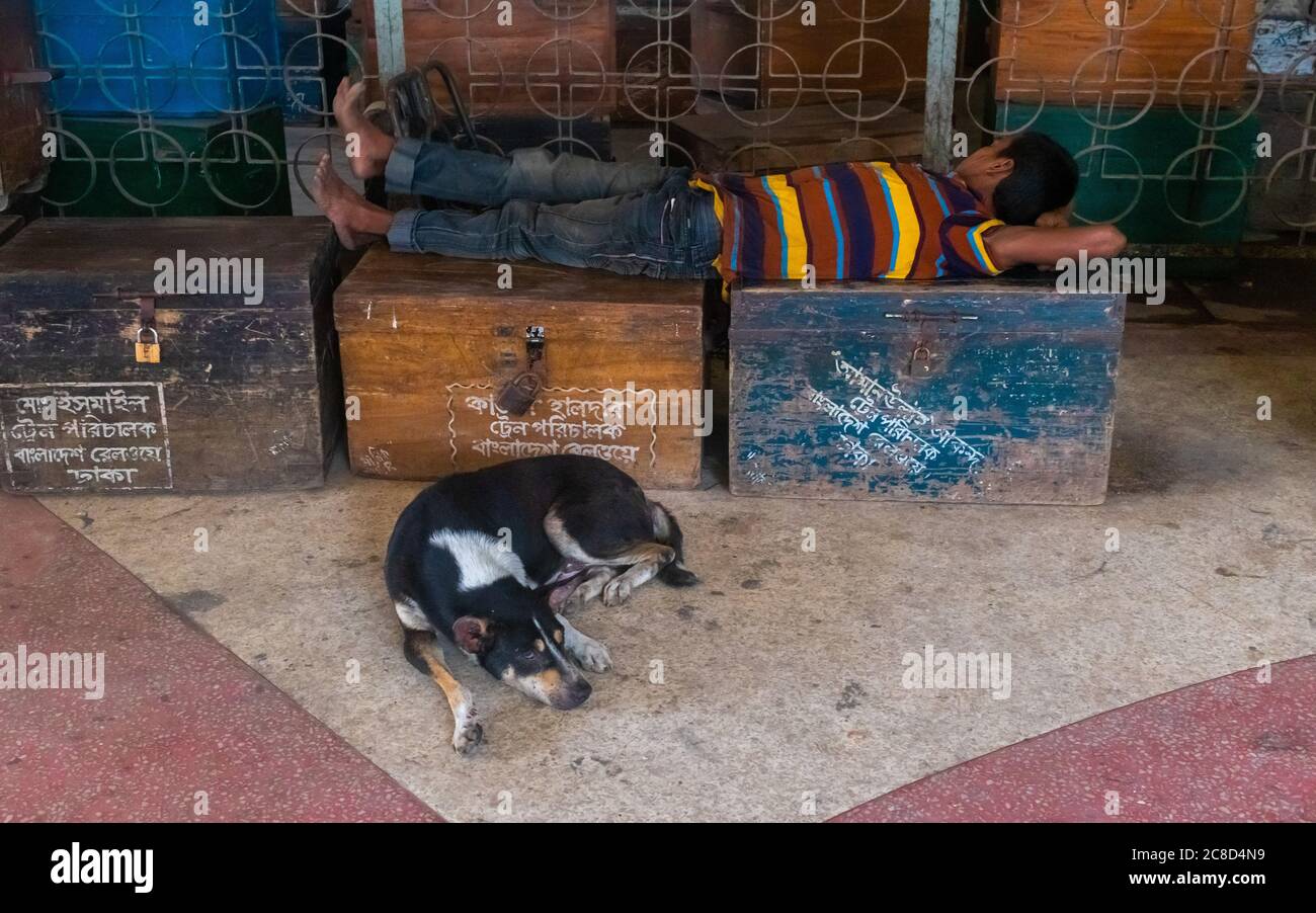 Ein Hund und ein Mann schlafen aufgrund Corona-Virus, es gibt keine Arbeit kein Essen. Ich habe dieses Bild von einem Bahnhof, der Kamalapur Eisenbahn s genannt wird, aufgenommen Stockfoto