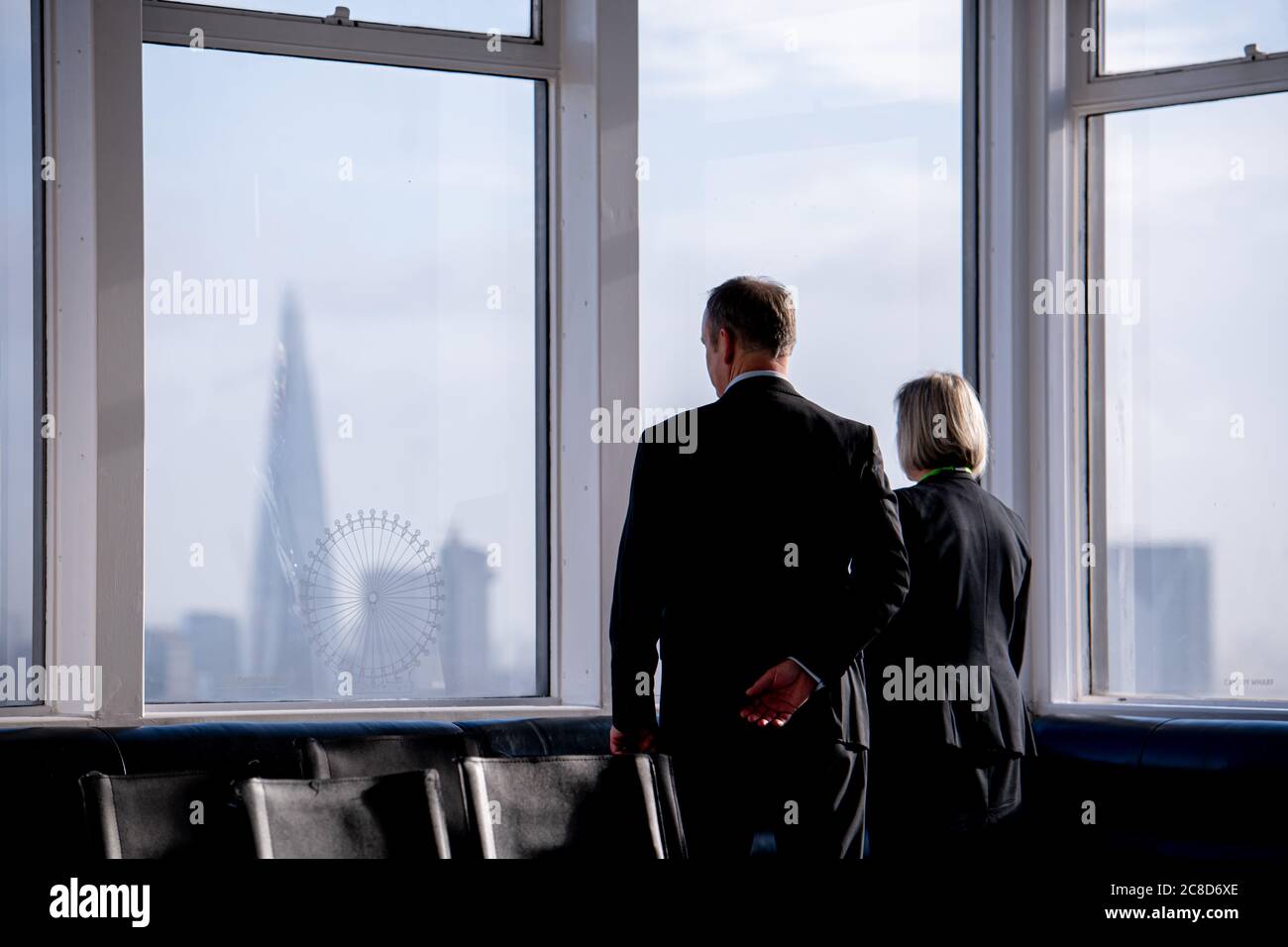 Zwei elegant gekleidete Geschäftsleute, die aus EINEM Fenster im The Shard in London schauen Stockfoto