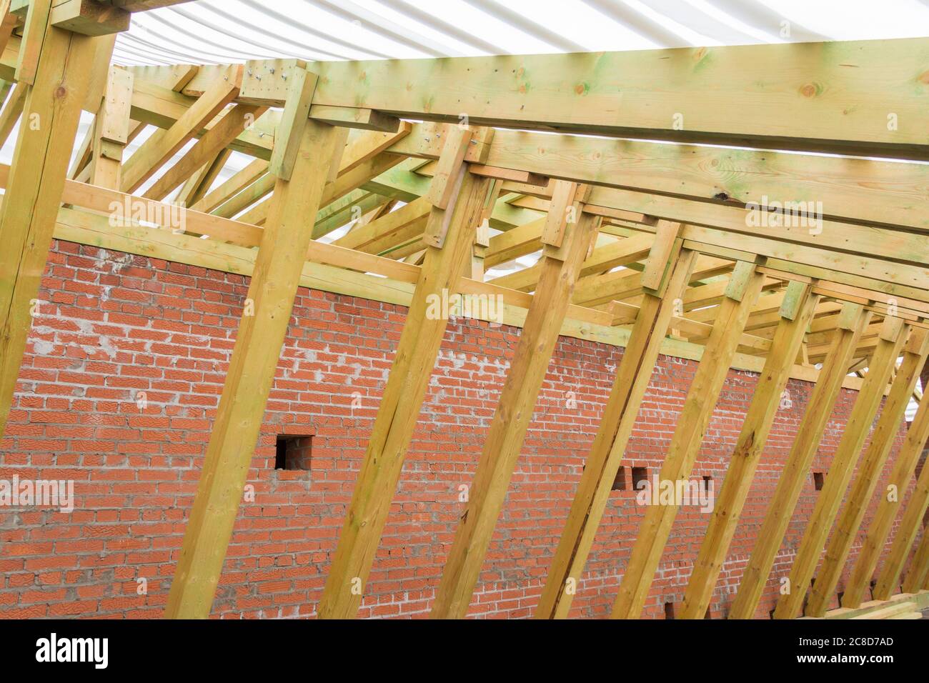 Holzkonstruktion des neuen Daches des im Bau befindlichen Gebäudes. Der Bau des Daches eines Wohnhauses. Stockfoto