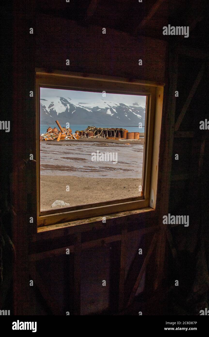 Blick durch ein Fenster von einem alten Haus, Teil der Überreste einer alten Walfangstation in Whalers Bay, in Port Foster, der Caldera von Deception Island Stockfoto