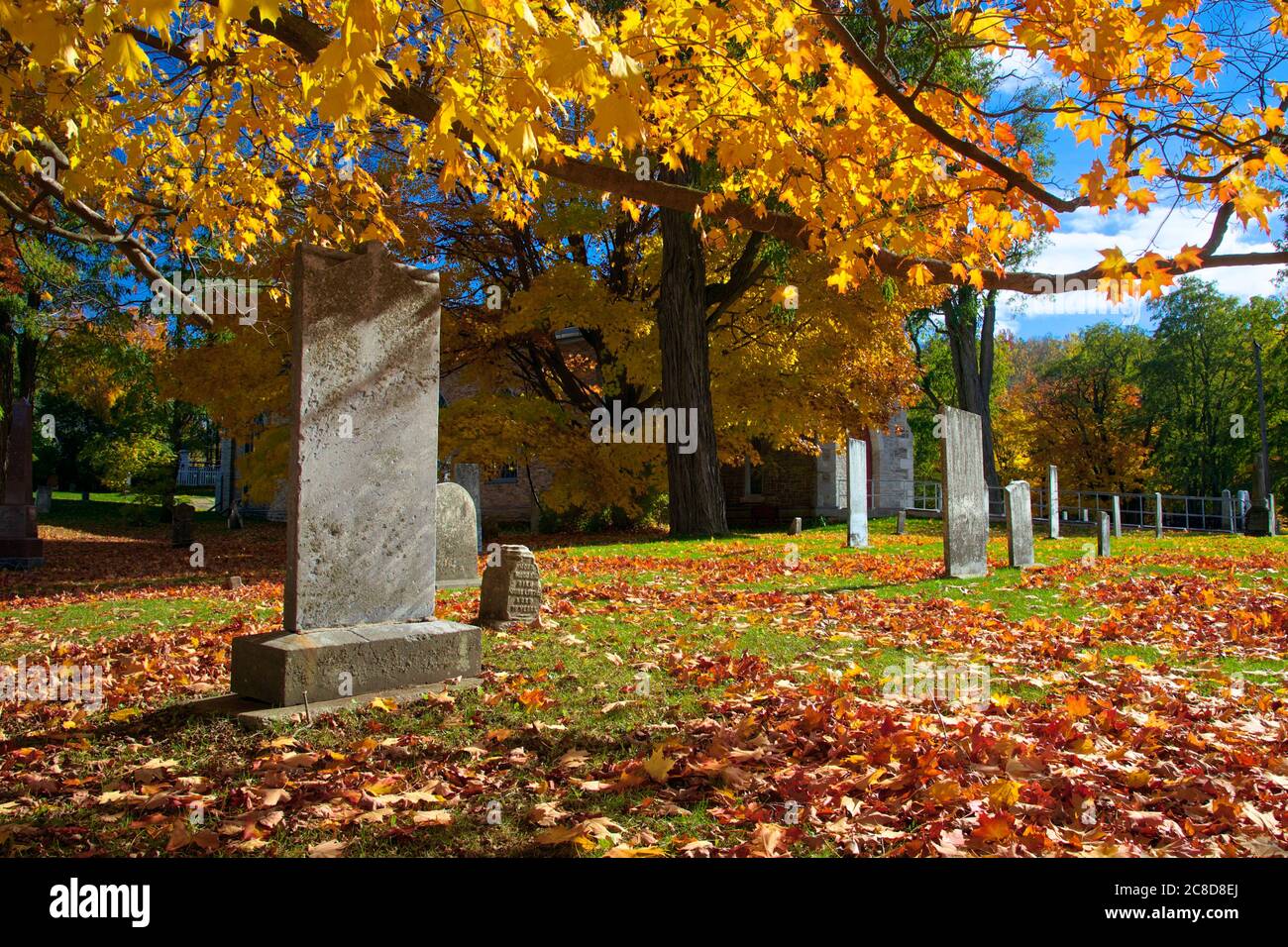 Grabstein und Gräber im Kirchengräbnisplatz im Herbst Stockfoto