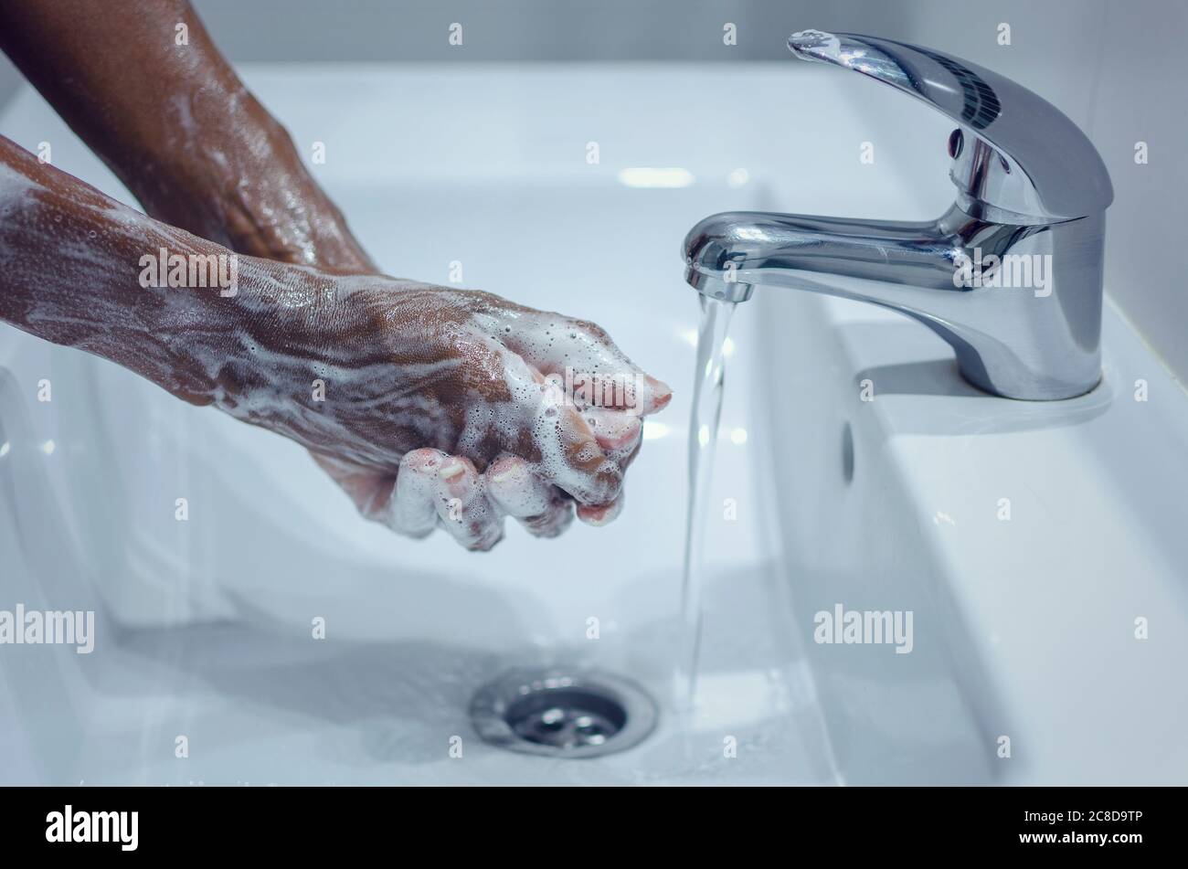 Schwarze Frau, die ihre Hände wusch und sie mit der Seife rieb. Covid-19 Prävention. Stockfoto