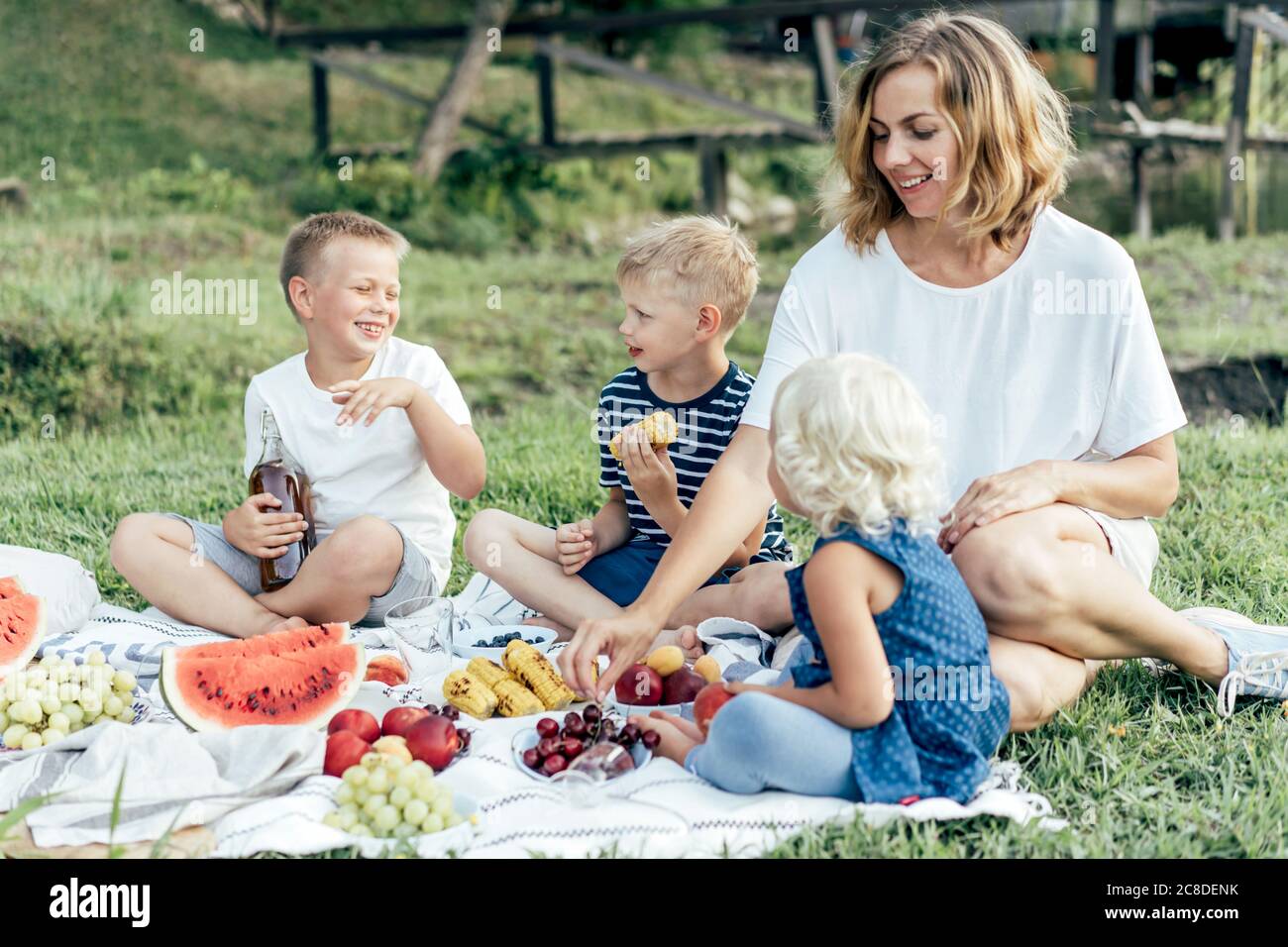 Mama mit Kindern im Park bei einem Picknick. Stockfoto
