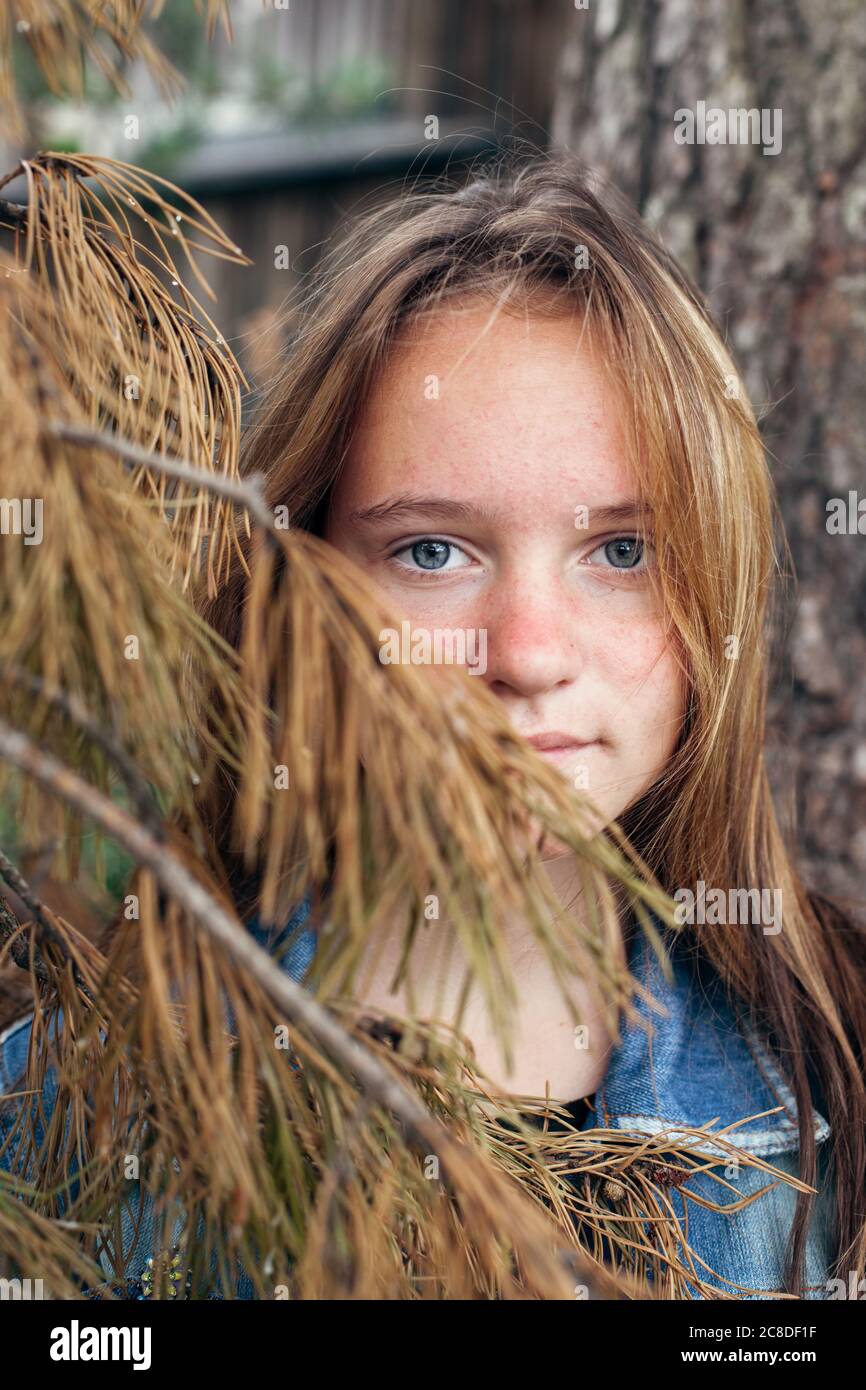 Porträt eines Teenagers in der Nähe einer Kiefer im Park. Stockfoto