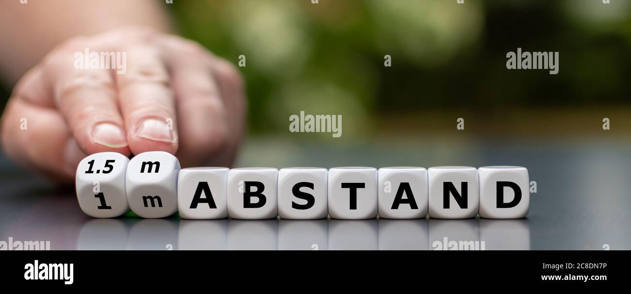 Symbol, um einen Mindestabstand von 1,5 m während der Corona-Krise zu halten. Würfel bilden den deutschen Ausdruck '1.5m Abstand' (1.5m Abstand). Stockfoto