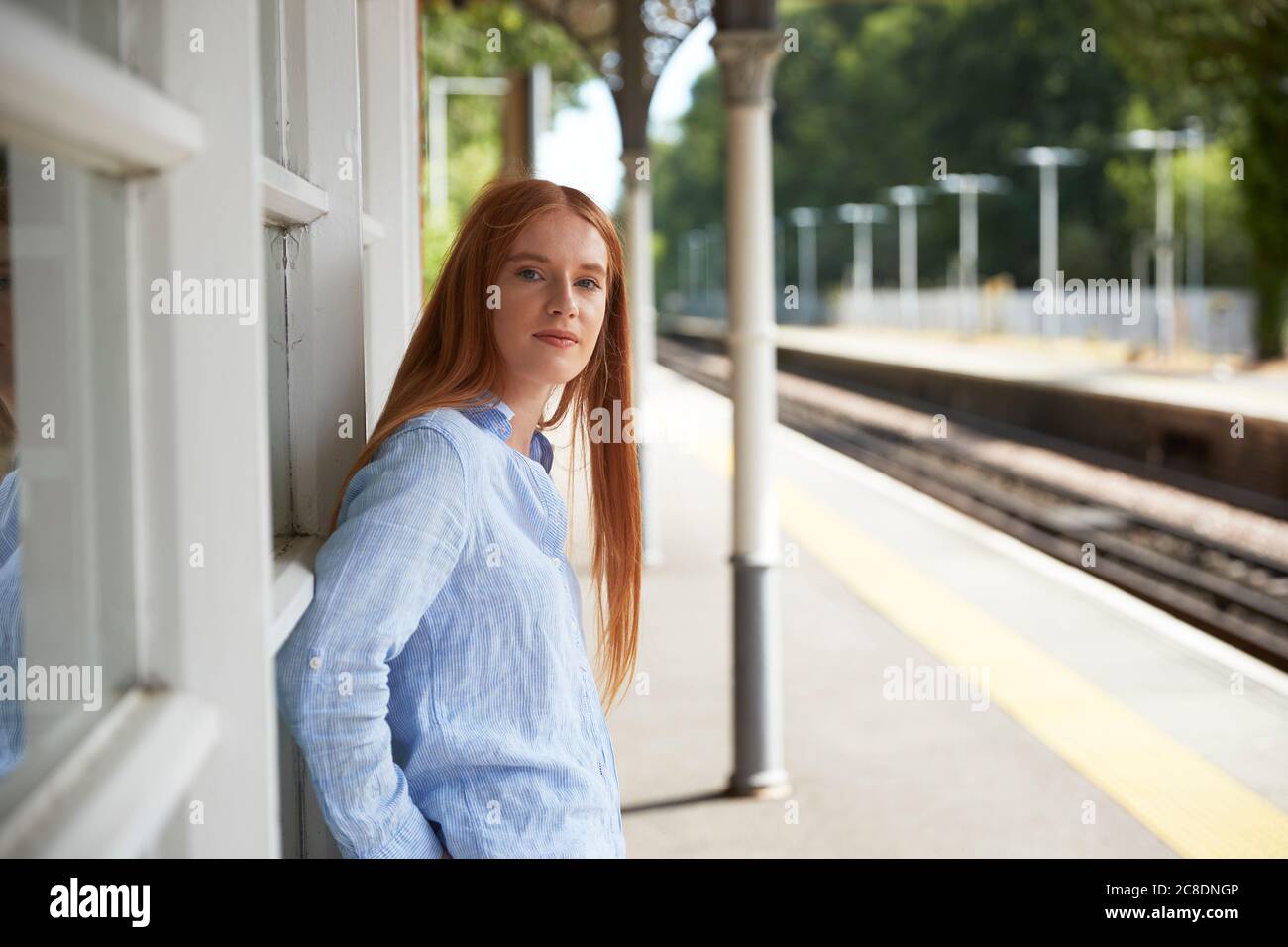 Schöne Frau, die am Bahnhofsplatz steht Stockfoto
