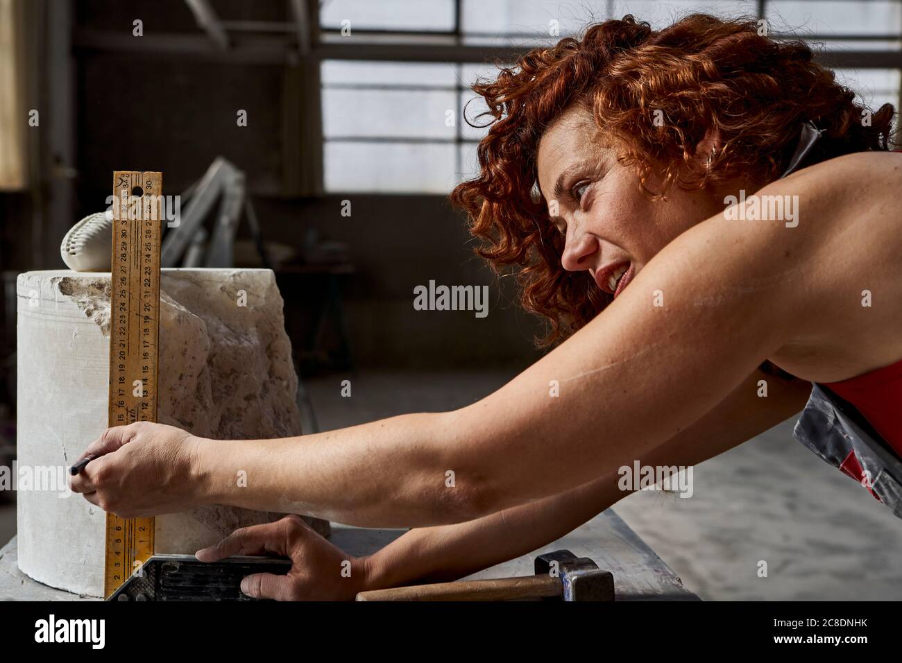 Nahaufnahme einer Frau, die Stein mit Lineal im Studio misst Stockfoto
