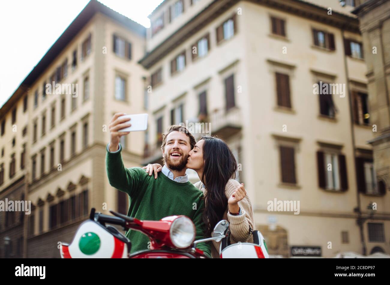 Mann nimmt Selfie mit Freundin küssen ihn auf Wangen in Florenz Stadt, Italien Stockfoto