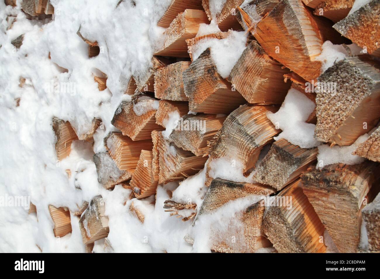 Textur von gestapeltem Brennholz im Winter Stockfoto