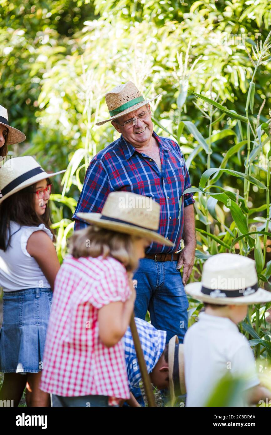 Grandfahter mit Gruppe von Kindern im Garten Stockfoto
