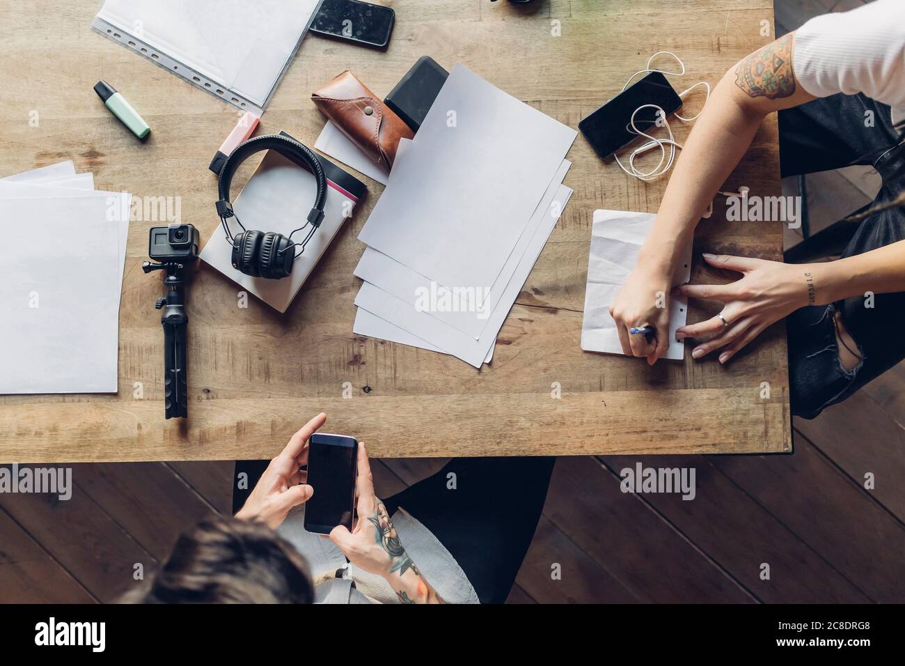 Zwei kreative Geschäftsleute, die am Holztisch arbeiten Stockfoto