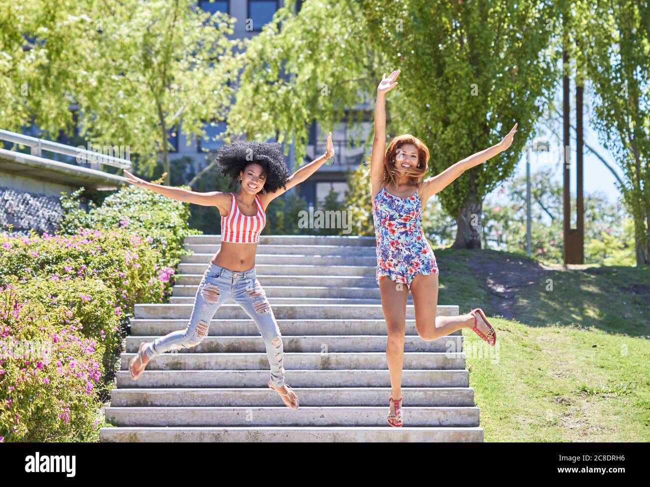 Freundinnen springen von Treppen im Park Stockfoto