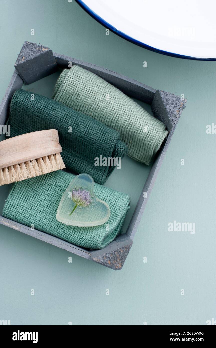Nagelbürste, Handtücher und Schnittlauch in herzförmigen Stück Glyzerinseife gegossen Stockfoto