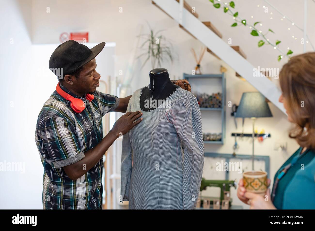 Junge männliche Designer-Trainee Prüfung Kleid auf Dummy von Profi Im Studio Stockfoto Junge männliche Designer-Trainee Prüfung Kleid auf Dummy von Profi Im Studio Stockfoto