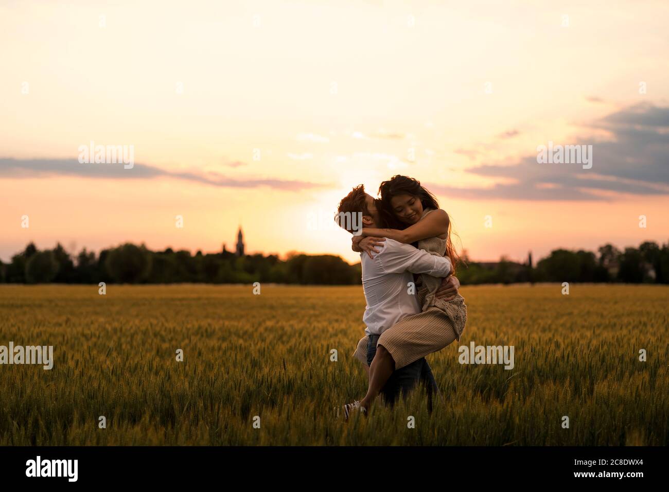 Tanzendes Paar auf dem Feld bei Sonnenuntergang Stockfoto