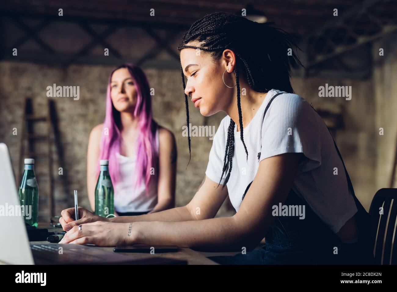 Zwei kreative Frauen arbeiten im Loft-Büro Stockfoto