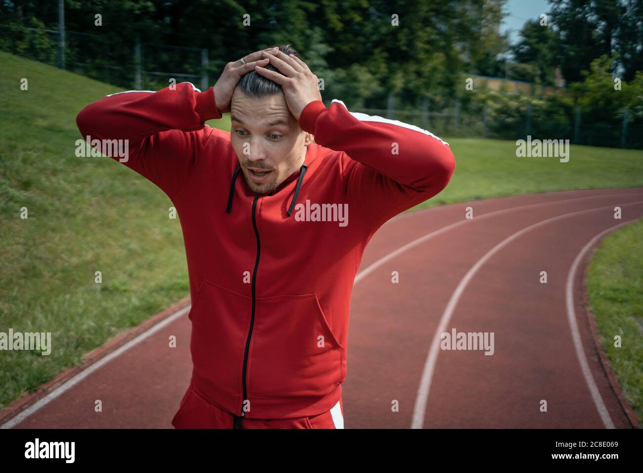 Erschöpfter Sportler, der sich nach dem Laufen oder Workout im Freien auf der Strecke ausruht Stockfoto
