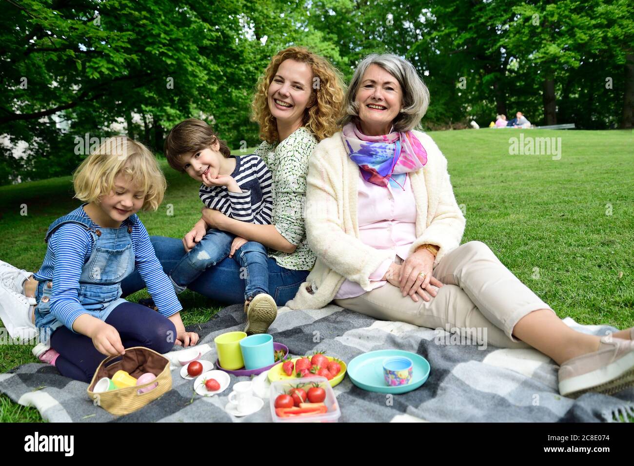 Glückliche drei Generationen Familie genießen Picknick im öffentlichen Park Stockfoto