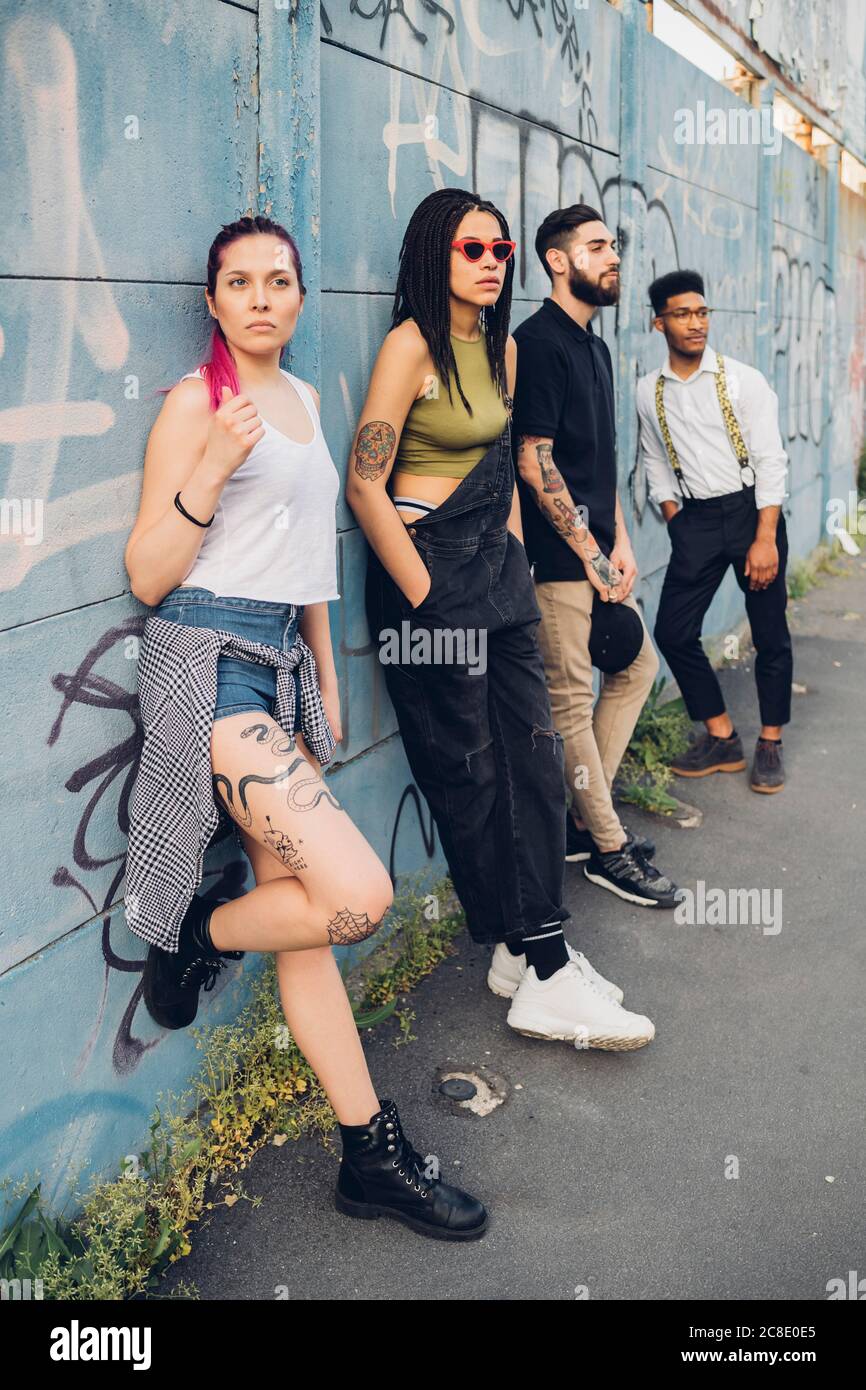 Gruppe von Freunden, die an einer Graffiti-Wand in der stehen Stadt Stockfoto