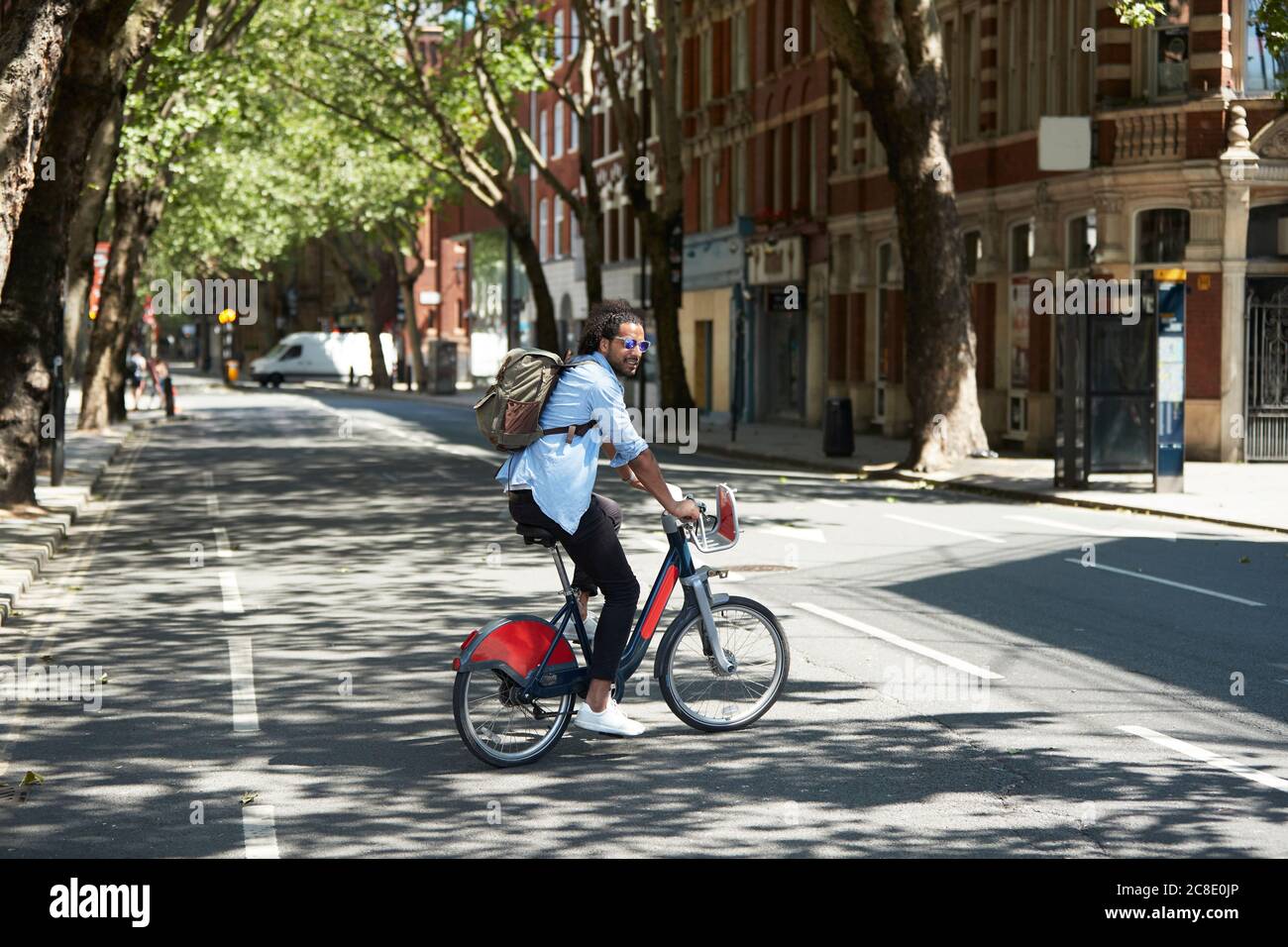 Junger Mann mit Leihrad in der Stadt, London, Großbritannien Stockfoto