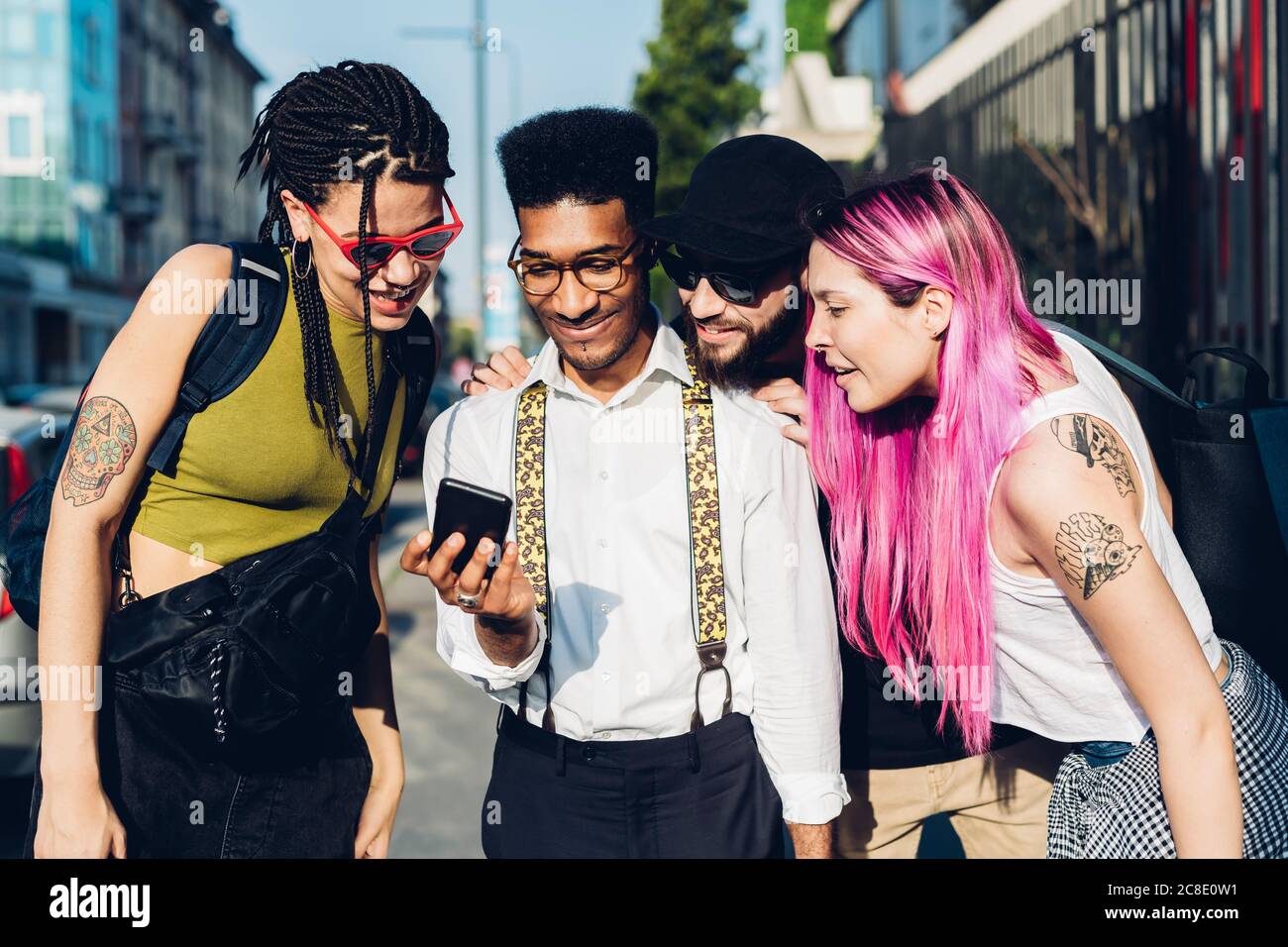Gruppe von Freunden, die ihr Smartphone in der Stadt teilen Stockfoto