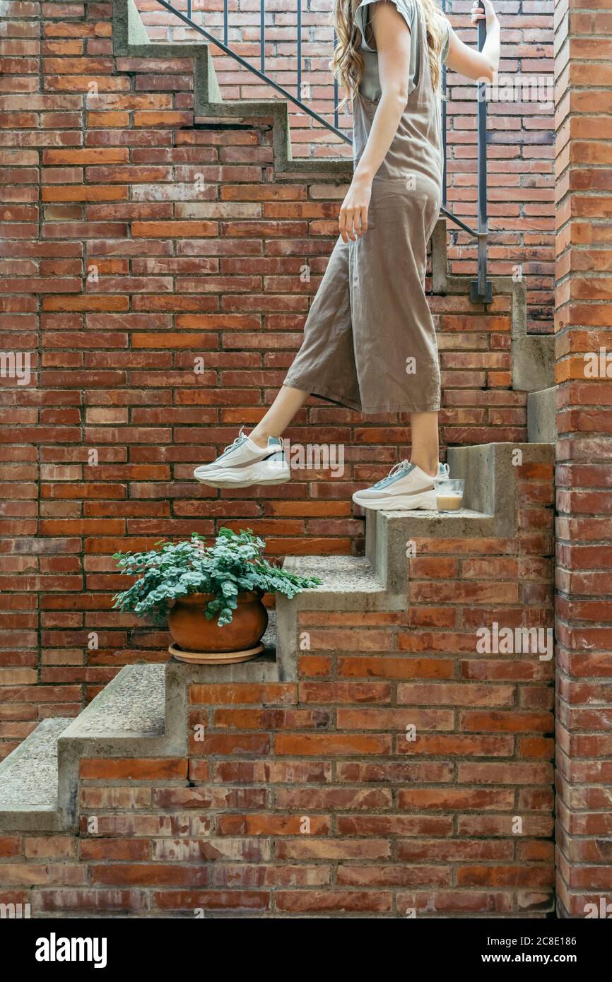 Junge Frau, die sich auf der Treppe nach unten bewegt Stockfoto