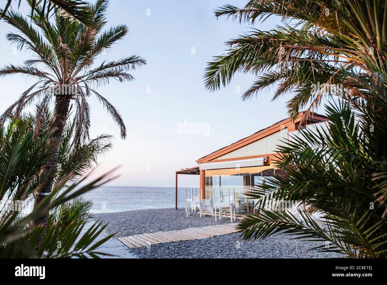 Spanien, Granada, Almunecar, Strandrestaurant mit Palmen im Vordergrund Stockfoto