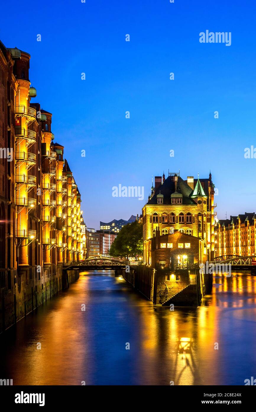 Deutschland, Hamburg, beleuchtetes Wasserschloss in Speicherstadt bei Dämmerung Stockfoto