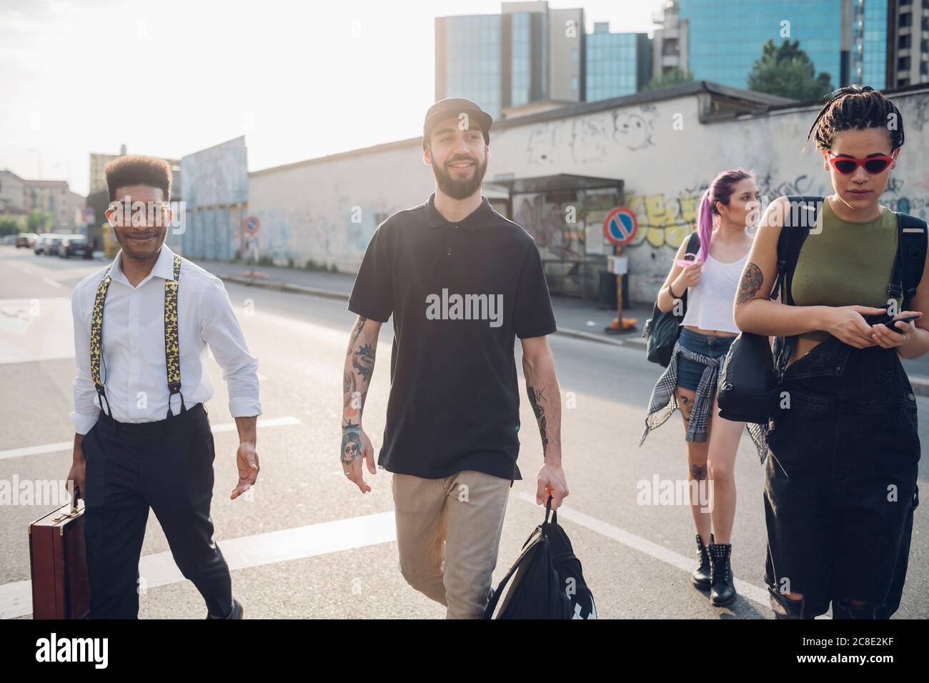 Eine Gruppe von Freunden, die auf einer Straße in der Stadt spazieren gehen Stockfoto