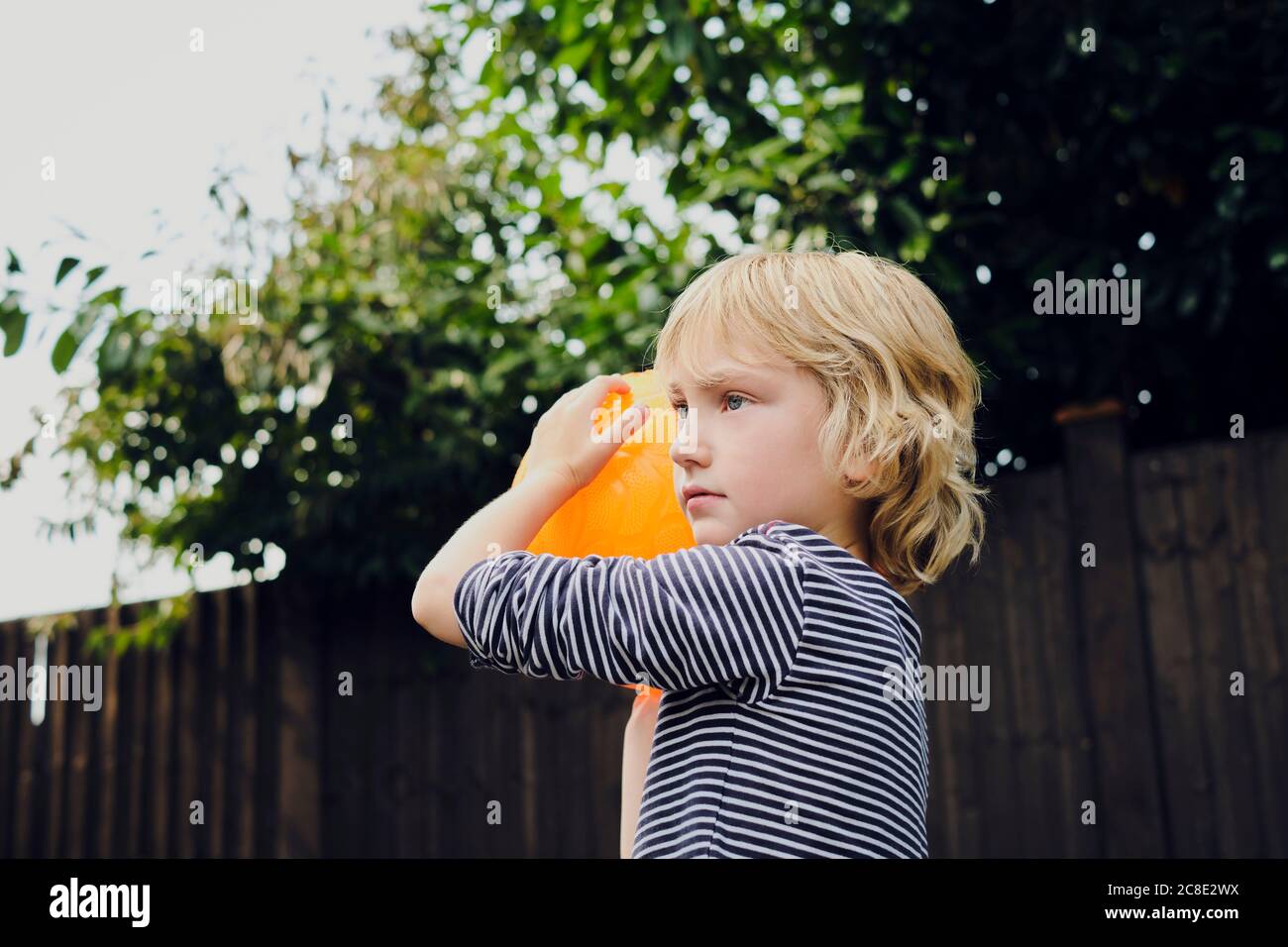 Junge spielt Basketball auf dem Hof Stockfoto