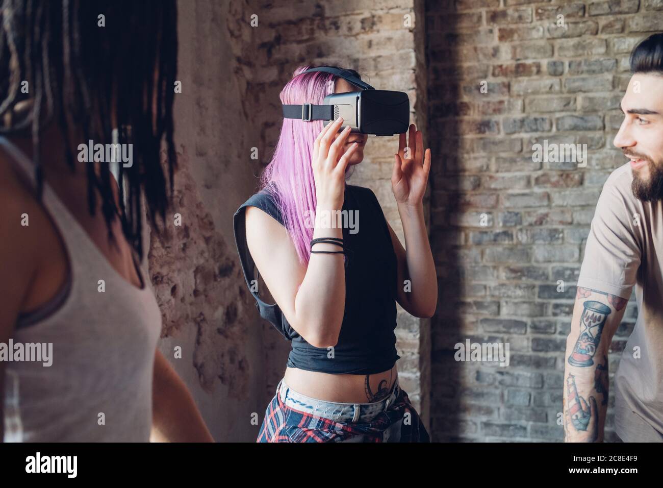 Kreatives Team mit VR-Brille im Loft-Büro Stockfoto