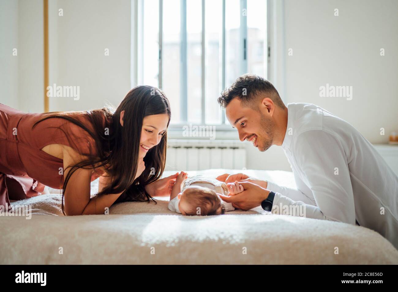 Glückliche Eltern spielen mit Baby Junge im Schlafzimmer zu Hause Stockfoto