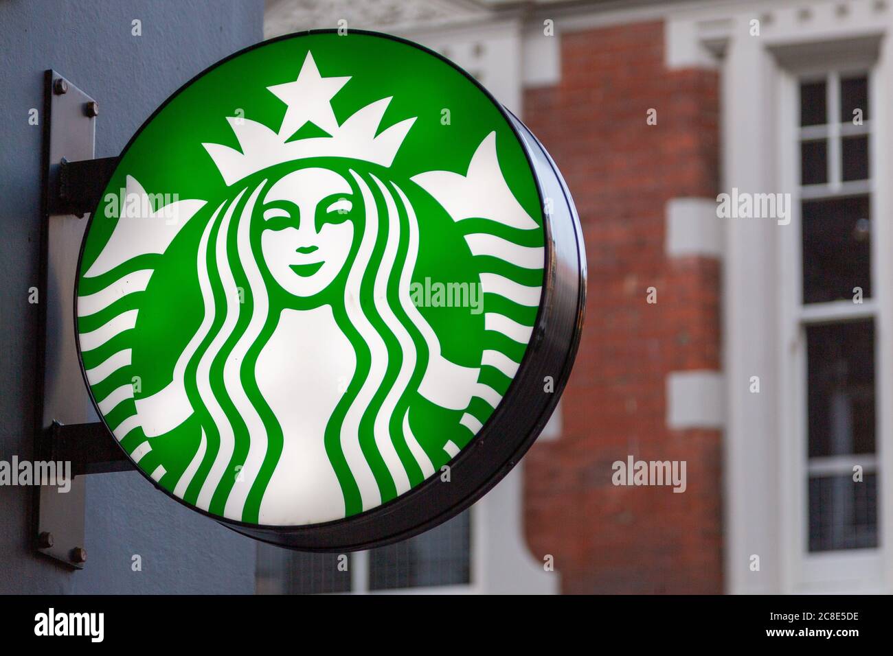 Ein beleuchtetes Schild mit dem Logo von Starbucks Kaffee an der Seite eines Gebäudes Stockfoto