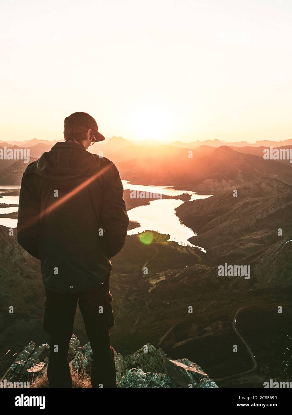 Männlicher Tourist, der während des Sonnenaufgangs auf dem Berg steht, Leon, Spanien Stockfoto