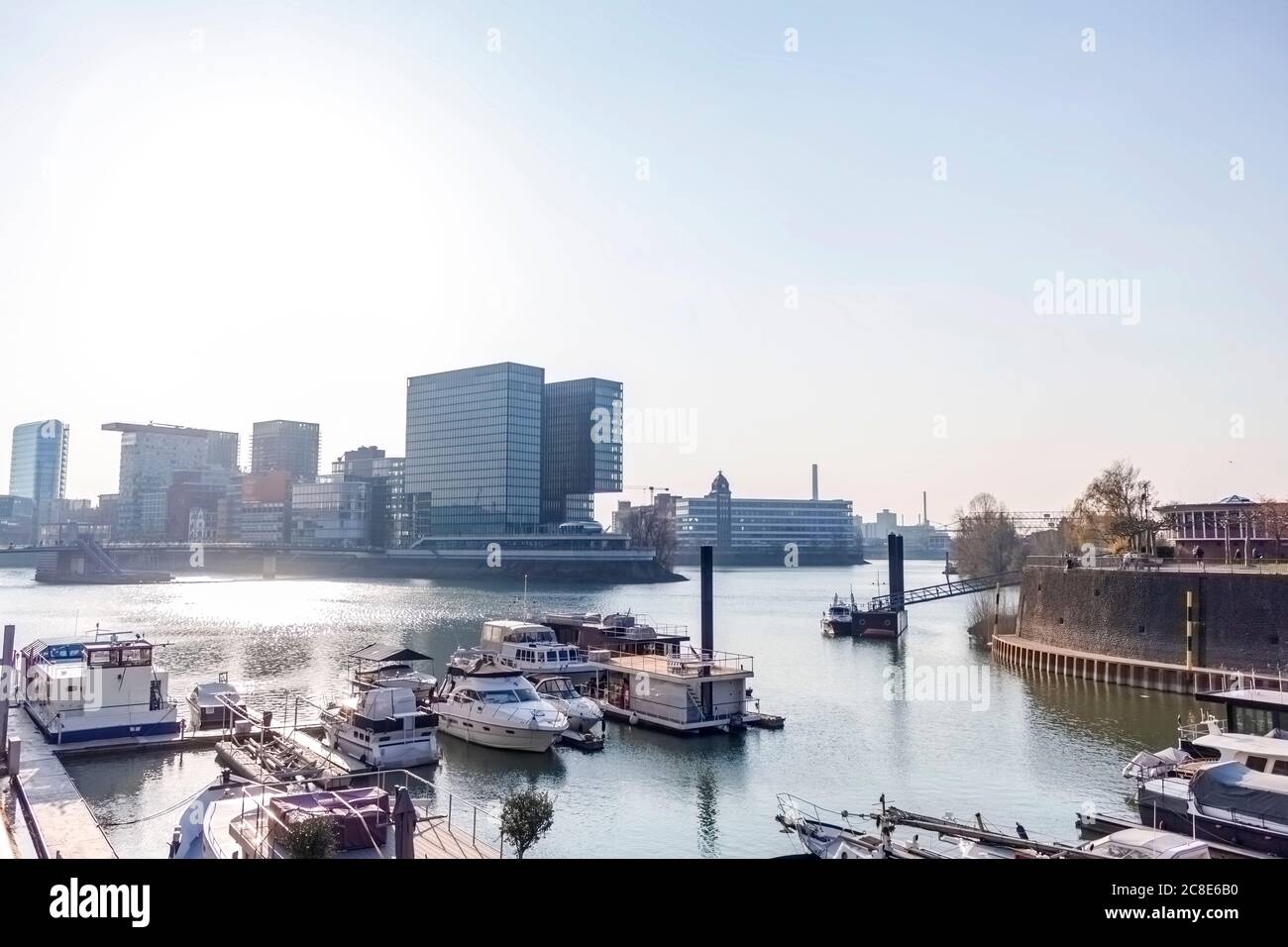 Deutschland, Nordrhein-Westfalen, Düsseldorf, Boote im Medienhafen mit Stadttor im Hintergrund Stockfoto