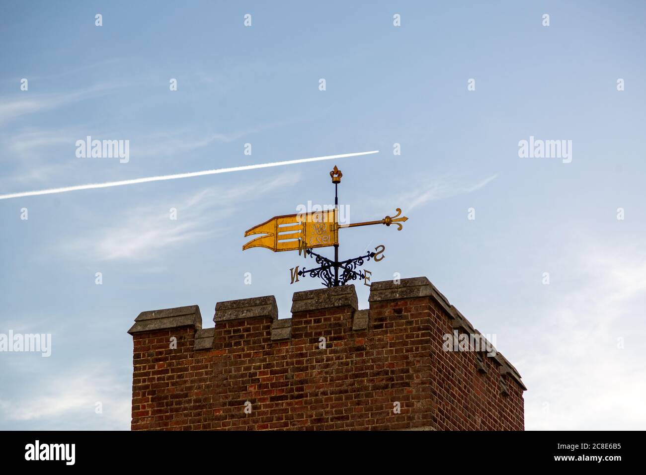 Eine Wetterfahne auf der Oberseite eines alten Ziegelgebäudes Stockfoto