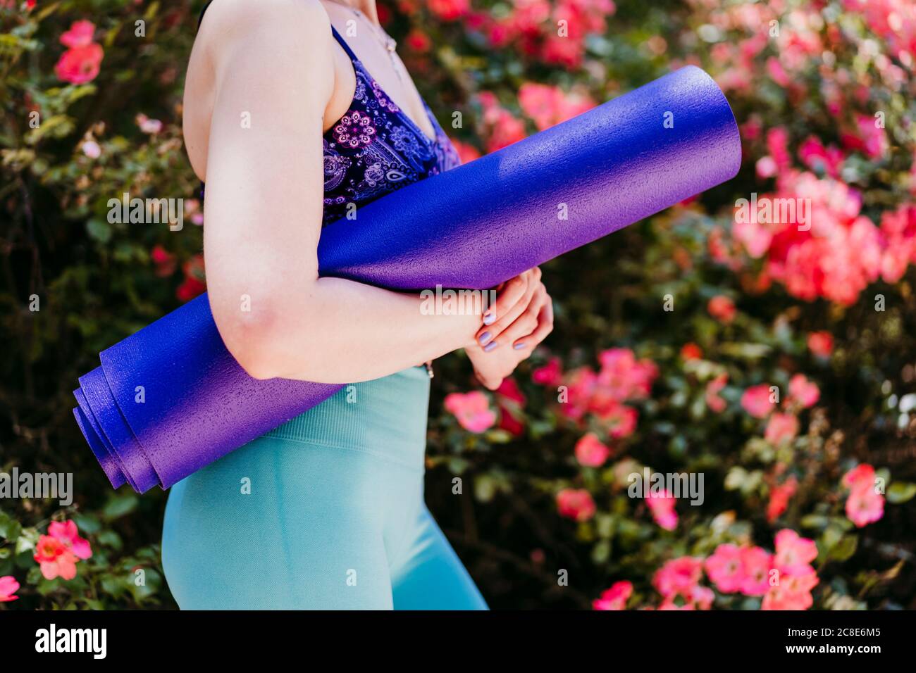 Fit Frau mit lila Yogamatte, während im Park stehen Stockfoto