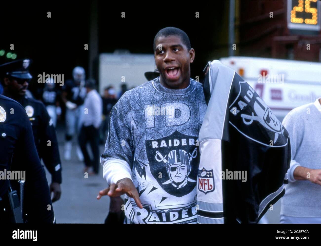 Magic Johnson in Raders Ausrüstung Teilnahme an einem L.A> Raiders Spiel im Coliseum in Los Angeles,1984 Stockfoto