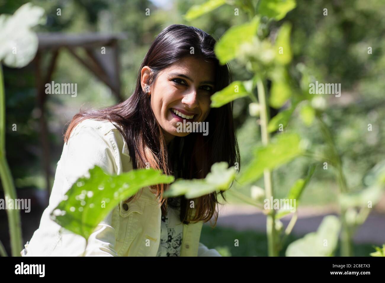 Glückliche Frau im städtischen Garten an sonnigen Tag Stockfoto