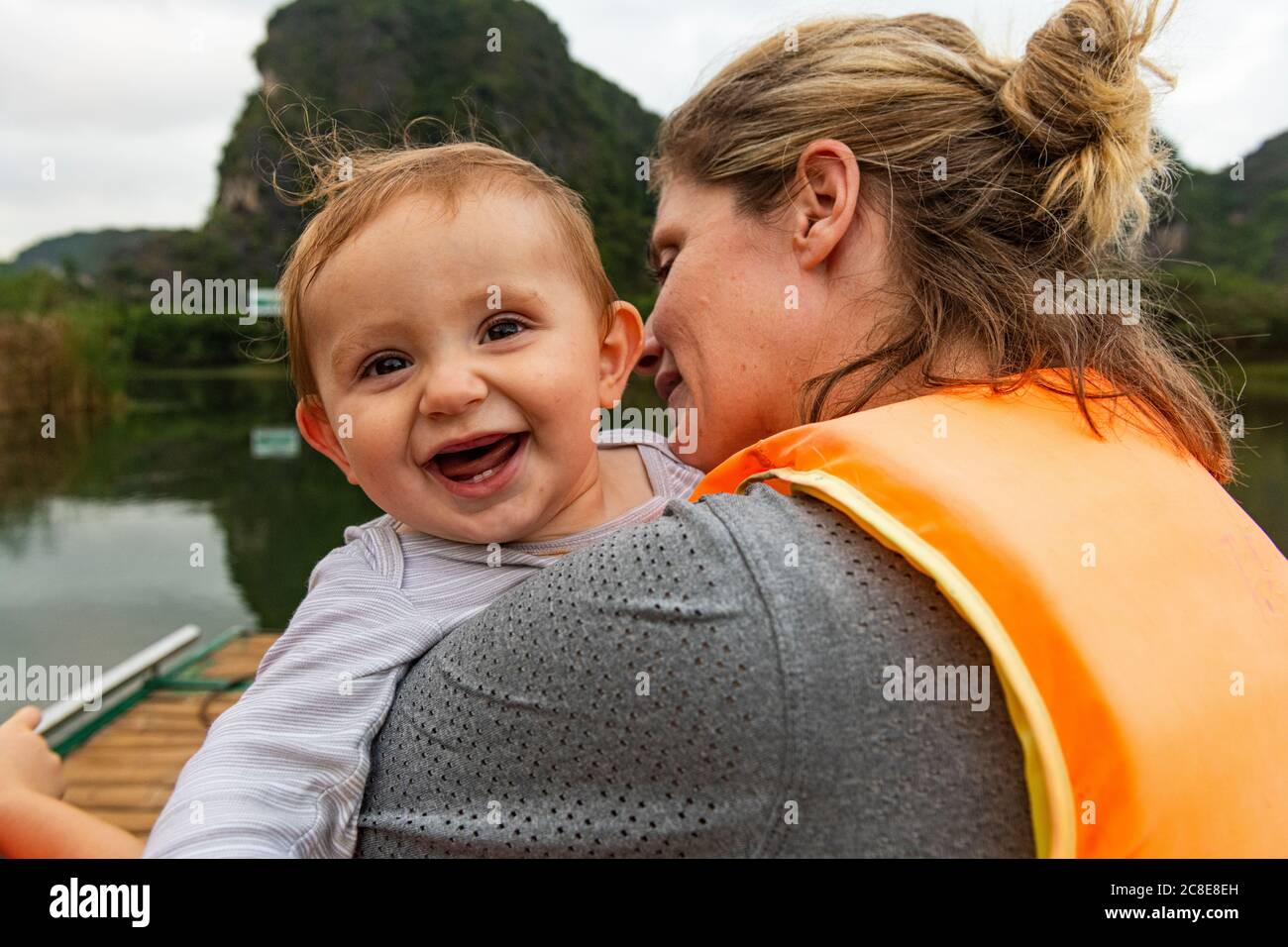Vietnam, Mutter mit Baby im Boot in Trang an Scenic Landscape Complex Stockfoto