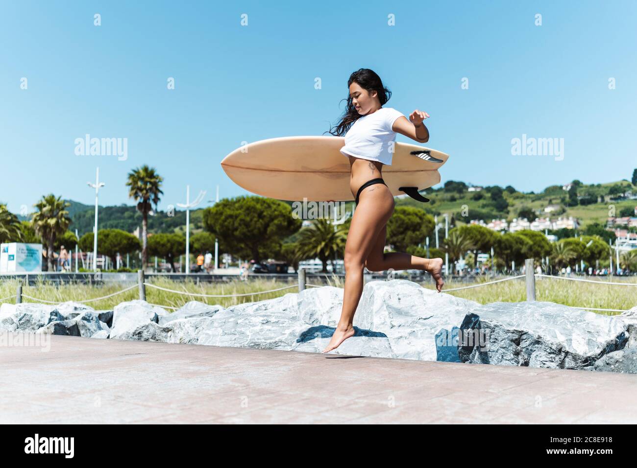 Weibliche Surferin mit Surfbrett im Freien Stockfoto